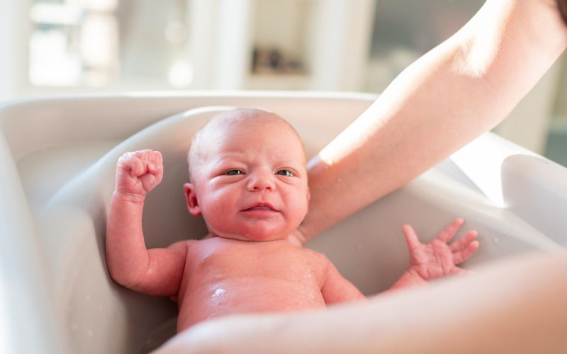 El Doctor Corta Las Uñas En La Mano De Un Bebé Recién Nacido